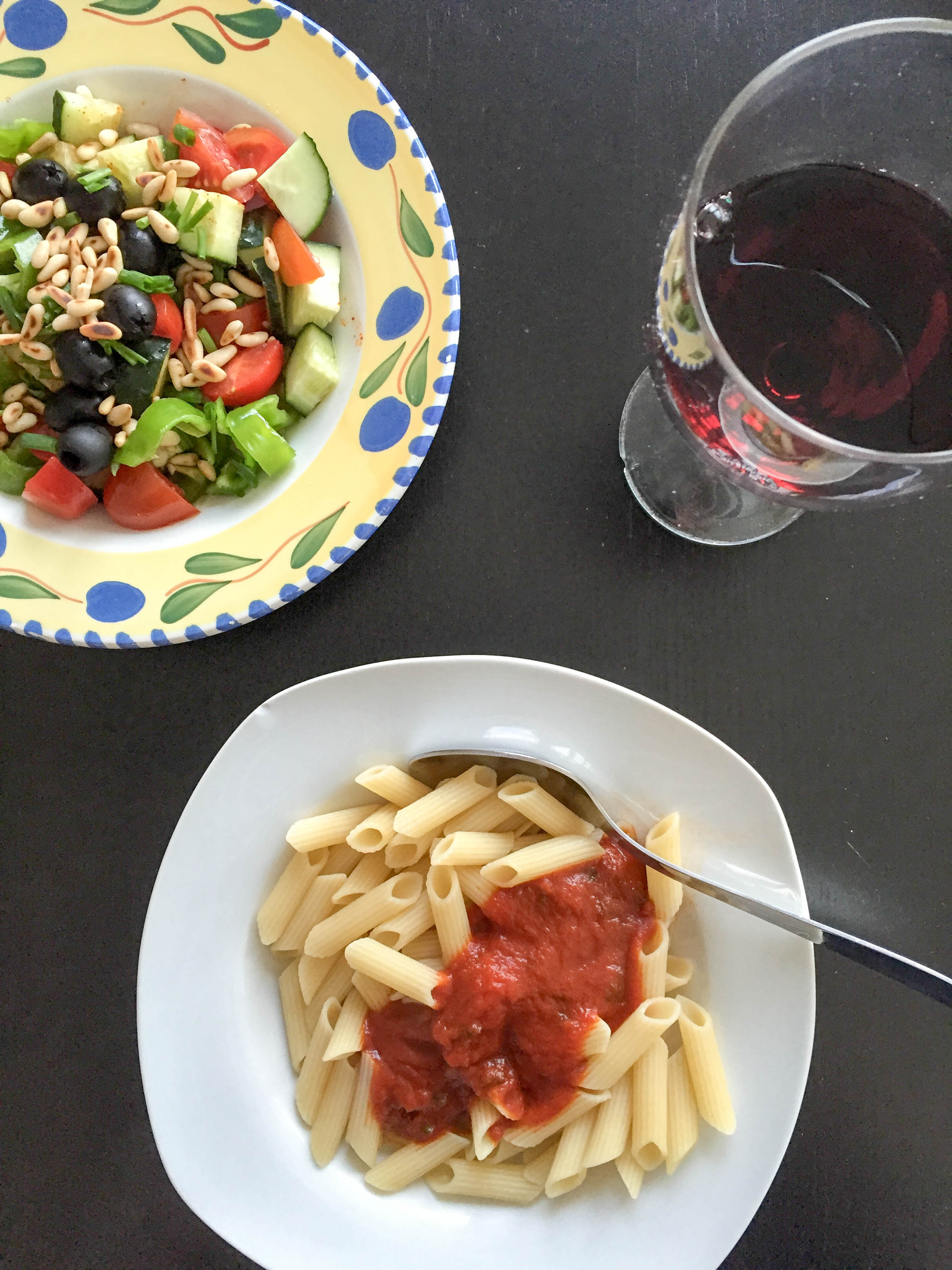 Abendessen Pasta mit Salat und Rotwein